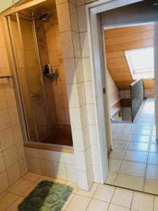 a bathroom with a shower with a glass door at HandwerkerZimmer in Düsseldorf