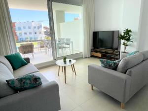 un soggiorno con 2 divani e una TV a schermo piatto di Apartamento en Costa Ballena a Chipiona
