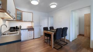 a kitchen with a table and chairs in a room at Cool Šilo Appartement Resort in Šilo