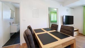 een eetkamer met een tafel en stoelen in een kamer bij Cool Šilo Appartement Resort in Šilo