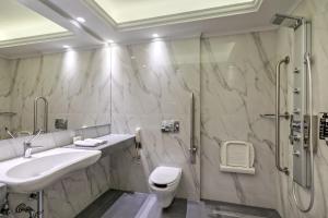 La salle de bains est pourvue d'un lavabo et d'une douche. dans l'établissement Estia Boutique Apartments, à Athènes