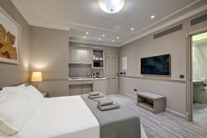 a bedroom with a large white bed and a kitchen at Estia Boutique Apartments in Athens