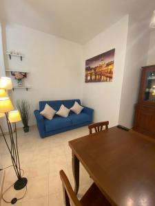 sala de estar con sofá azul y mesa en Noemi’s Home, en Roma