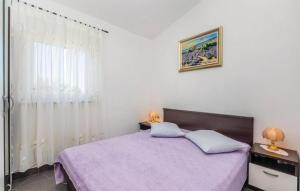 - une chambre avec un lit doté de draps violets et une fenêtre dans l'établissement Apartmani Ivanković, à Karlobag