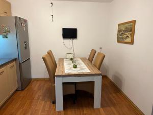 a kitchen with a table with chairs and a refrigerator at CASA DON lângă Iulius Mall in Timişoara