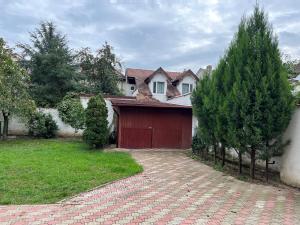 una casa con un garaje rojo y algunos árboles en CASA DON en Timisoara
