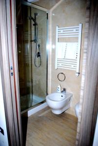 uma casa de banho com um chuveiro, um lavatório e um WC. em Piazza Dante em Taranto