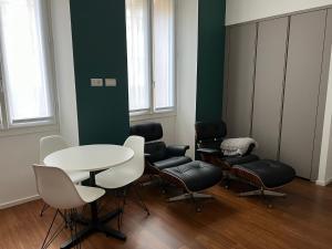 - une salle d'attente avec une table et des chaises dans l'établissement Ariosto Social Club, à Milan