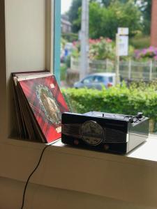 une radio assise sur un rebord de fenêtre à côté d'une horloge dans l'établissement Staying with the artist, à Teuven