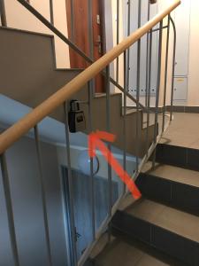 a metal stair railing with an orange ribbon on it at Cosy studio in quiet location in Puławy