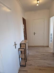 an empty room with a table and a door at Appartement spacieux rénové - 11 min de Paris in Colombes