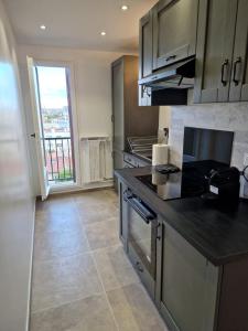 a kitchen with stainless steel appliances and a large window at Appartement spacieux rénové - 11 min de Paris in Colombes
