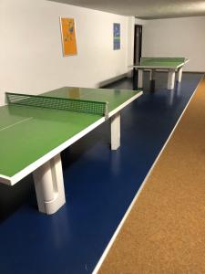 due tavoli da ping pong in una stanza vuota con di FERIENWOHNUNG FORSTPANORAMA a Sankt Englmar