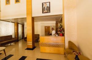 a man standing at a counter in a hotel lobby at Hotel La Luna in Beni Mellal