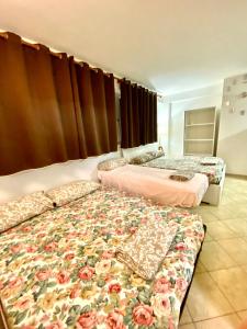 two beds in a bedroom with a floral bed spread at Lucky’s house in Noicattaro