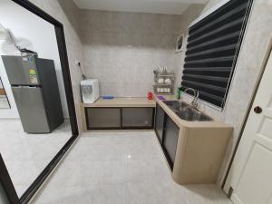 Voon 2 bedroom homestay في ميرسينغ: مطبخ صغير مع مغسلة وثلاجة