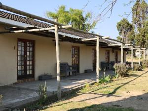 Weaver's Nest Country Inn في Wakkerstroom: بيت فيه بريغولا جنبه
