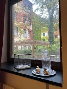 ein Fensterbrett mit einem Teller Gebäck und einem Glas-Glas in der Unterkunft Rut & Ragnars Vandrarhem in Malmö