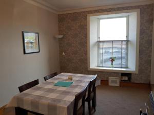 a dining room with a table and a window at House by the Harbour - NC500 Route in Wick