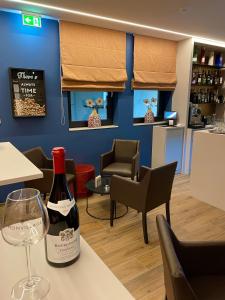 a bottle of wine sitting on a table in a restaurant at Hotel Monvillage in Mondercange