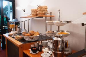 a breakfast buffet with bread and food on a counter at Hotel am Weiher in Erkelenz