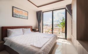 Un dormitorio con una cama y una ventana grande. en Uy Dương Hotel & Apartment - Nha Trang, en Nha Trang 66 fotos más