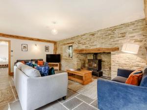 a living room with two couches and a fireplace at Penshenkin Barn in Llanfihangel-nant-Melan