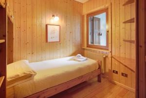 ヴァルディソットにあるMountain Chalet close to Bormioのベッドと窓が備わる小さな客室です。