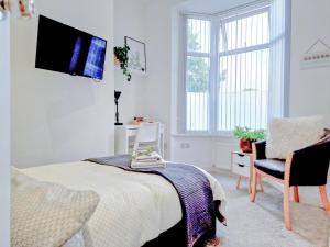 - une chambre avec un lit et une télévision murale dans l'établissement Tropicana House, à Barnsley