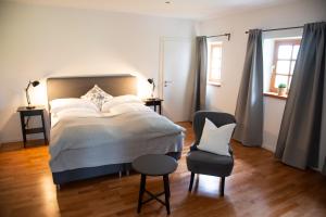 a bedroom with a large bed and a chair at Seehof direkt am See in Seeleiten