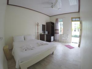 una camera bianca con un letto bianco e un tavolo di Konut by Thakuru a Guraidhoo