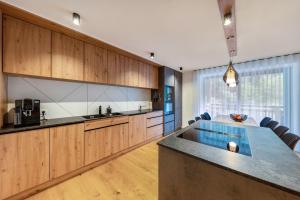 a large kitchen with wooden cabinets and a blue island at Apartment Ub31 One in Eggen