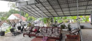 three chairs under a canopy on a patio at kopi ABG in Lawang