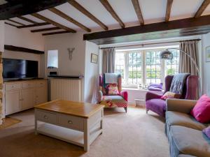 een woonkamer met een bank en een tafel bij Pass the Keys Delightful 4 bedroom Cotswold character cottage in Cheltenham