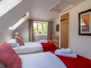twee bedden in een kamer met een raam bij Pass the Keys Delightful 4 bedroom Cotswold character cottage in Cheltenham