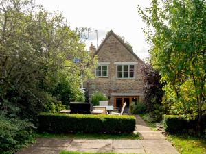 a brick house with a garden and a patio at Pass the Keys Delightful 4 bedroom Cotswold character cottage in Cheltenham