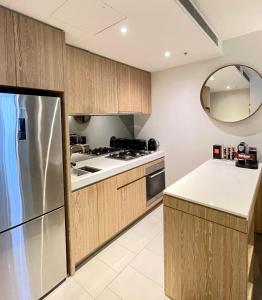 a kitchen with wooden cabinets and a stainless steel refrigerator at Boutique Abode 8 in Melbourne