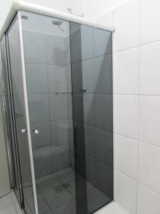 La salle de bains est pourvue d'une douche en verre et de toilettes. dans l'établissement Nébias Palace Hotel junto da Avenida Ipiranga com São João em Frente ao Bar Brahma SP, à São Paulo
