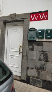 a garage with a white door and a car parked outside at ka Sánchez vecindario in Vecindario