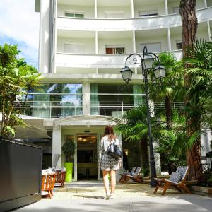 a woman walking in front of a building at Hotel Luxor in Milano Marittima