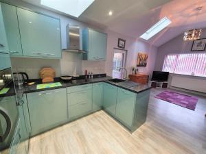a kitchen with blue cabinets and a living room at Priory Annex Guest Accommodation Lincoln in Lincolnshire +13 photos