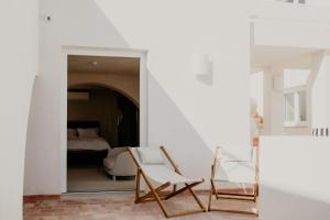 オリョンにあるCasa dos Mercadosの椅子2脚とベッド1台が備わる客室です。