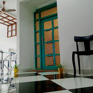 a green door in a room with a black chair at VIAN INN in Guwahati