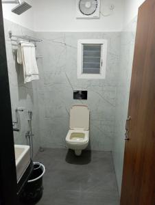 a bathroom with a white toilet and a sink at VIAN INN in Guwahati