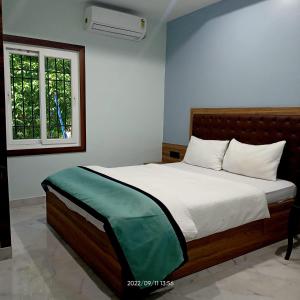 um quarto com uma cama com lençóis brancos e uma janela em VIAN INN em Guwahati