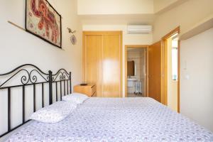 a bedroom with a bed with a white bedspread at 121 MEDANO Perfect Stay By Sunkeyrents in El Médano