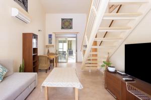 a living room with a couch and a staircase at 121 MEDANO Perfect Stay By Sunkeyrents in El Médano