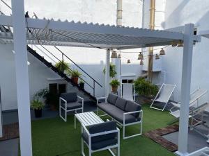 eine Terrasse mit Stühlen und einem Tisch auf einem Gebäude in der Unterkunft Gran casa señorial de 300m en centro histórico in El Puerto de Santa María