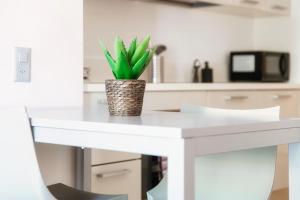 a white desk with a potted plant on it at Prestige 7 by Quokka 360 - quiet studio with balcony in Lugano