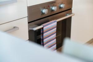 a kitchen oven with a striped towel hanging from it at Prestige 7 by Quokka 360 - quiet studio with balcony in Lugano